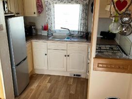 a kitchen with a fridge, sink, and stove at Bell Bank Caravan Park - Holiday Accommodation 20266, Chapel St Leonards