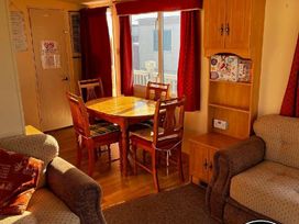 a dining area with a wooden table and chairs at Bell Bank Caravan Park - Holiday Accommodation 20266, Chapel St Leonards