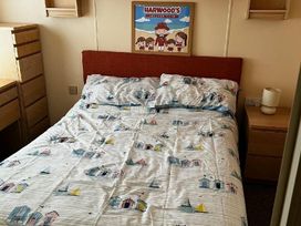 a bedroom with a bed featuring patterned bedding and a picture on the wall at Bell Bank Caravan Park - Holiday Accommodation 20266 Chapel St Leonards