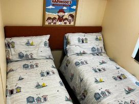 a bedroom with two beds featuring patterned sheets at Bell Bank Caravan Park - Holiday Accommodation 20266, Chapel St Leonards