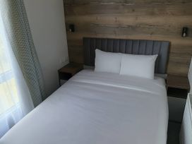 A bedroom with a bed and bedside table at Lakeland Leisure Park - Holiday Accommodation 20349, Grange-Over-Sands