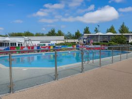 An outdoor swimming pool with slides and a fence at Lakeland Leisure Park - Holiday Accommodation 20349 in Grange-Over-Sands