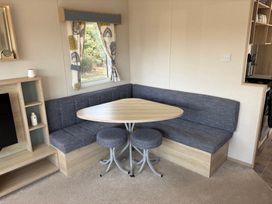 A dining area with a table and bench seating at Skipsea Sands Holiday Park - Holiday Accommodation 20390, Driffield