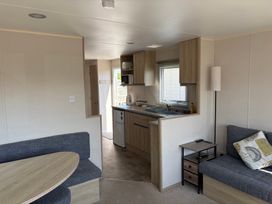 A living room with a kitchen and sofa at Skipsea Sands Holiday Park - Holiday Accommodation 20390, Driffield