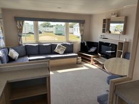 A living room with a sofa and television at Skipsea Sands Holiday Park - Holiday Accommodation 20390 Driffield