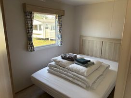 A bedroom with bed and folded linens at Skipsea Sands Holiday Park - Holiday Accommodation 20390, Driffield