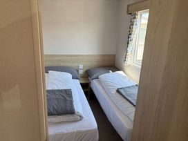 A bedroom with two single beds and a window at Skipsea Sands Holiday Park - Holiday Accommodation 20390, Driffield