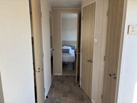 A hallway with multiple doors leading to rooms at Skipsea Sands Holiday Park - Holiday Accommodation 20390, Driffield