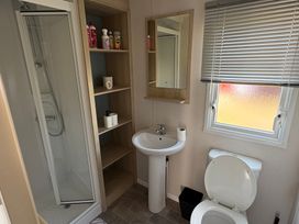 A bathroom with a shower, toilet, and sink at Skipsea Sands Holiday Park - Holiday Accommodation 20390, Driffield