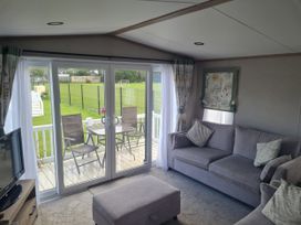 A living room with sliding doors leading to a deck at Seashore Holiday Park - Holiday Accommodation 20465 Great Yarmouth