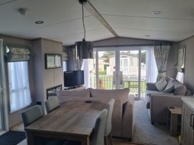 A living room with a table and sofa at Seashore Holiday Park - Holiday Accommodation 20465, Great Yarmouth