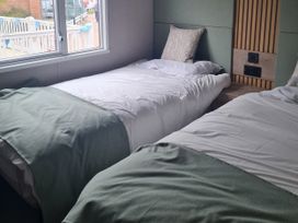 A bedroom with two beds and a window at Seashore Holiday Park - Holiday Accommodation 20465, Great Yarmouth