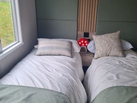 A bedroom with two beds and a window at Seashore Holiday Park - Holiday Accommodation 20465 Great Yarmouth