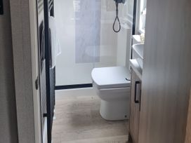 A bathroom with a toilet, shower, and sink at Seashore Holiday Park - Holiday Accommodation 20465 in Great Yarmouth