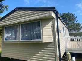 The exterior of a mobile home with windows and a deck at Hafan y Mor Haven - Holiday Accommodation 20501 Pwllheli