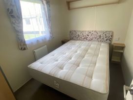 A bedroom with a bed and window at Hafan y Mor Haven - Holiday Accommodation 20501 Pwllheli