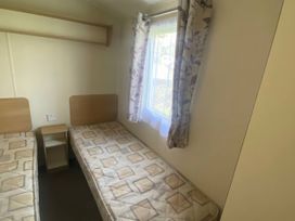 A bedroom with two beds and a window at Hafan y Mor Haven - Holiday Accommodation 20501 Pwllheli