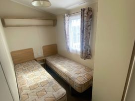 A bedroom with two single beds and a window at Hafan y Mor Haven - Holiday Accommodation 20501 Pwllheli