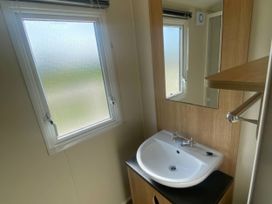 A bathroom with a sink and a mirror at Hafan y Mor Haven - Holiday Accommodation 20501, Pwllheli