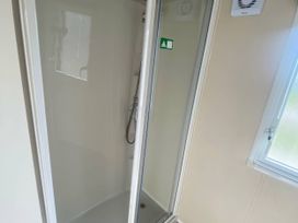A shower enclosure with a showerhead in a bathroom at Hafan y Mor Haven - Holiday Accommodation 20501 Pwllheli