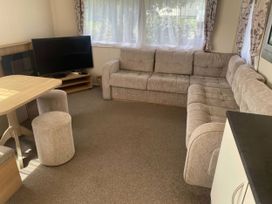 A living room with a sofa and TV at Hafan y Mor Haven - Holiday Accommodation 20501 in Pwllheli