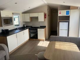 A kitchen with appliances and a table at Hafan y Mor Haven - Holiday Accommodation 20501 Pwllheli