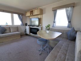 A living room with sofa, TV, and coffee table at Golden Sands Kinmel Bay - 20528 Rhyl