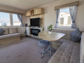 A living room with a sofa, table, and television at Golden Sands Kinmel Bay - 20528, Rhyl