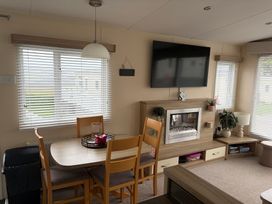 A dining room with a table and chairs at Liskey Hill Caravan Park - Holiday Accommodation 20540, Perranporth