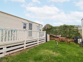 A garden with a caravan, hammock and picnic table at Golden Gate Holiday Centre - Holiday Accommodation 20618 in Abergele