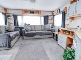 A living room with a sofa and side table at Golden Gate Holiday Centre - Holiday Accommodation 20618, Abergele