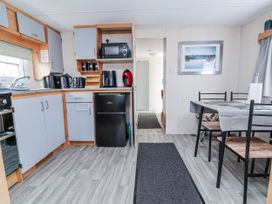 A kitchen with appliances and dining area at Golden Gate Holiday Centre - Holiday Accommodation 20618 in Abergele