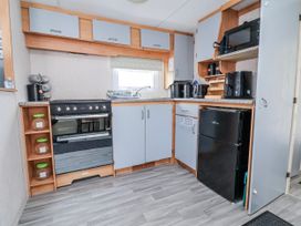 A kitchen with appliances and storage at Golden Gate Holiday Centre - Holiday Accommodation 20618, Abergele
