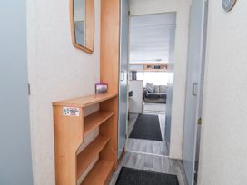 A hallway with a shelf and mirror at Golden Gate Holiday Centre - Holiday Accommodation 20618, Abergele