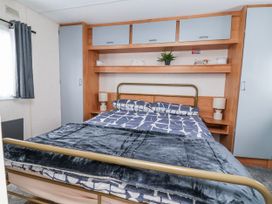 A bedroom with a bed and bedside tables at Golden Gate Holiday Centre - Holiday Accommodation 20618, Abergele