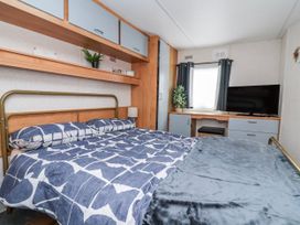 A bedroom with a bed, desk, and television at Golden Gate Holiday Centre - Holiday Accommodation 20618 Abergele