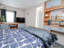 A bedroom with a TV and desk at Golden Gate Holiday Centre - Holiday Accommodation 20618 Abergele