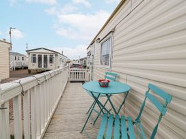An outdoor area with a table and chairs at Golden Gate Holiday Centre - Holiday Accommodation 20618 Abergele