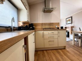 A kitchen with cabinets, sink, and gas cooktop at Thornwick Bay Holiday Village - Holiday Accommodation 20633, Flamborough