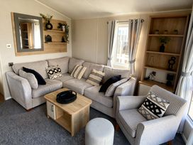 A living room with a sofa, armchair, and coffee table at Thornwick Bay Holiday Village - Holiday Accommodation 20633, Flamborough
