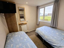 A bedroom with two single beds and a television at Thornwick Bay Holiday Village - Holiday Accommodation 20633, Flamborough