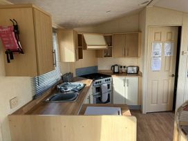 A kitchen with a stove, sink, and cupboards at Seaview Caravan Park - Holiday Accommodation 20846 Ingoldmells, Skegness
