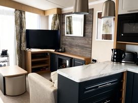 A living room with a television and coffee table at Lyons Robin Hood - Holiday Accommodation 20871 Rhyl