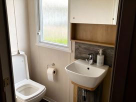 A bathroom with a toilet and sink at Lyons Robin Hood - Holiday Accommodation 20871, Rhyl