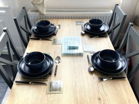 A dining table set with bowls and cutlery at Lyons Robin Hood - Holiday Accommodation 20871 Rhyl