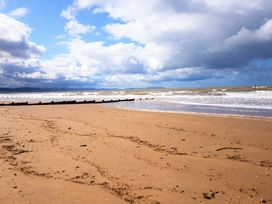 A beach with waves hitting the shore and wooden posts at Lyons Robin Hood - Holiday Accommodation 20871 Rhyl