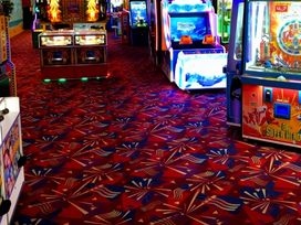 An entertainment area with arcade games and coin machines at an amusement center