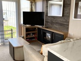 A living room with a television and a coffee table at Lyons Robin Hood - Holiday Accommodation 20871 Rhyl