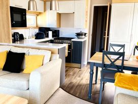 A kitchen area with a dining table and seating at Lyons Robin Hood - Holiday Accommodation 20871 Rhyl