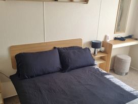A bedroom with a bed and desk at Trecco Bay - Holiday Accommodation 20876 Porthcawl